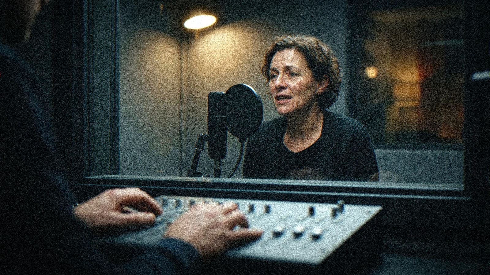 Comédienne en cabine d'enregistrement pendant une session de voix pour un court-métrage IA
